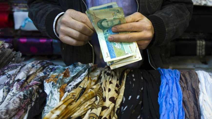 EDITORS' NOTE: Reuters and other foreign media are subject to Iranian restrictions on leaving the office to report, film or take pictures in Tehran.
A shopkeeper counts Iranian bank notes at his shop in a bazar in Tehran February 25, 2012. REUTERS/Raheb Homavandi (IRAN - Tags: SOCIETY BUSINESS) - RTR2YFBH