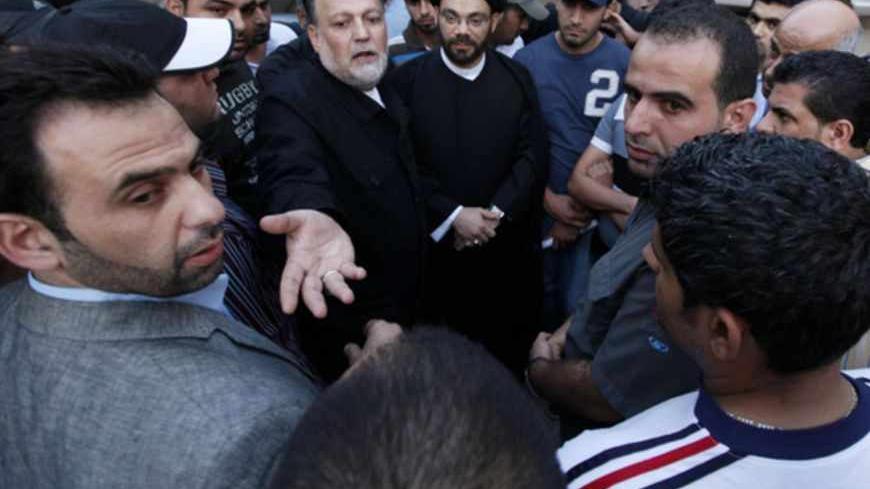 Lebanon Hezbollah parliament members Ali Ammar (C) and Sayyed Nasrat Kashakesh talk to the families of kidnapped Lebanese Shi'ite pilgrims, during a sit-in in Beirut's suburbs May 23, 2012.  The kidnap by Syrian gunmen of Lebanese Shi'ite pilgrims caused international allies and adversaries of President Bashar al-Assad to sound an alarm on Wednesday about a spread of sectarian violence across Syria's borders. REUTERS/ Jamal Saidi (LEBANON - Tags: CIVIL UNREST POLITICS CRIME LAW) - RTR32IXJ