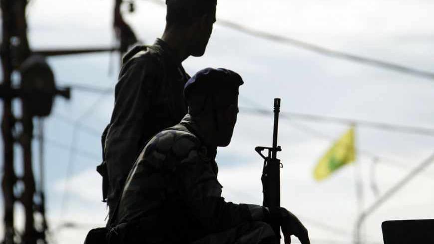 A Hezbollah flag flutters in the background as Lebanese army soldiers patrol near the site where fighting broke out on Sunday between supporters of Lebanon's Sunni Muslim Salafist leader Ahmad al-Assir and supporters of Lebanon's Hezbollah in Sidon, southern Lebanon November 12, 2012. Three people were killed on Sunday when fighting broke out in the Lebanese coastal city of Sidon between followers of the Sunni Salafist preacher and supporters of the Lebanese Shi'ite guerrilla movement Hezbollah, a security 