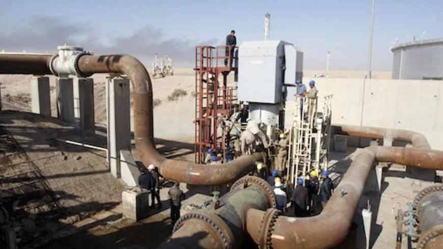 Employees of the state-run South Oil Company (SOC) join a new oil storage tank to the oil pipelines near the southern city of Basra January 14, 2013. The head of the state-run South Oil Company said the new facility will add a capacity of one million barrels to the existing 5.5 million barrels available. REUTERS/Atef Hassan (IRAQ - Tags: ENERGY CIVIL UNREST) - RTR3CG6G