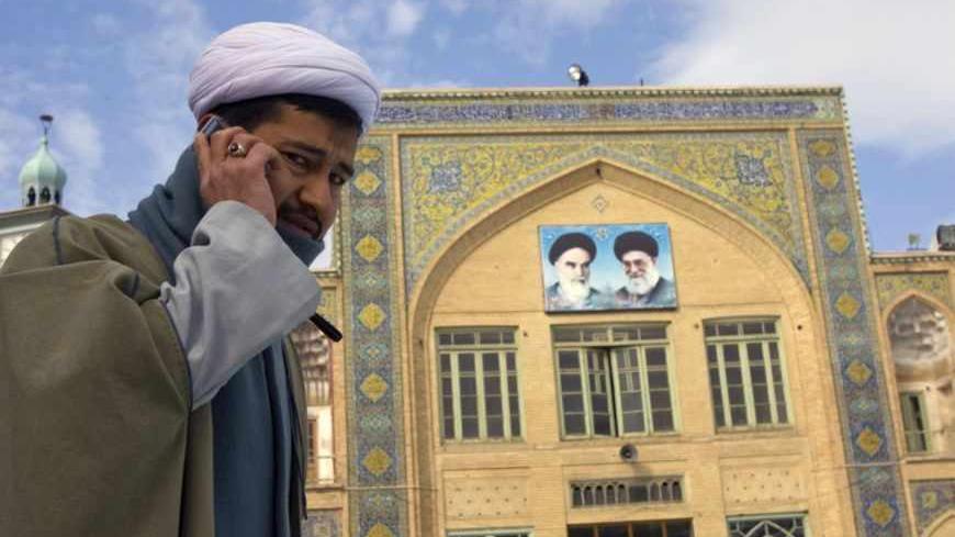 A cleric speaks on his mobile phone on the campus of the Seminary in Qom, 120 km (75 miles) south of Tehran February 3, 2009. REUTERS/Caren Firouz  (IRAN) - RTXB72O