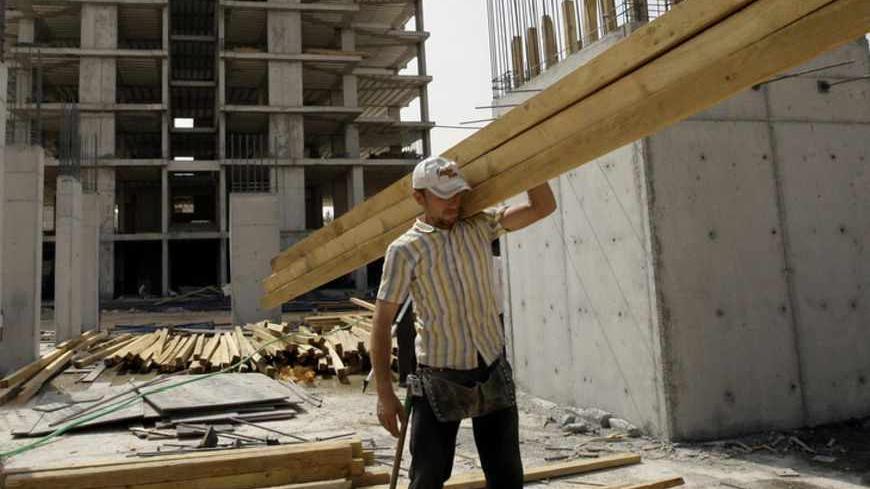 A man works at a construction site in Iraq's northern province of Arbil September 25, 2010. While most Iraqis struggle under the detritus of a seven-year war, the people of Arbil in Iraqi Kurdistan can frolic in a public pool, ride an elevated cable car over freshly planted parkland or escape stifling heat in a new ice skating hall. The new luxuries of Iraq's northern Kurdish region seem a world apart from the dust and grit of Baghdad, where suicide bombers are an everyday fear, dirt-gray blast walls domina