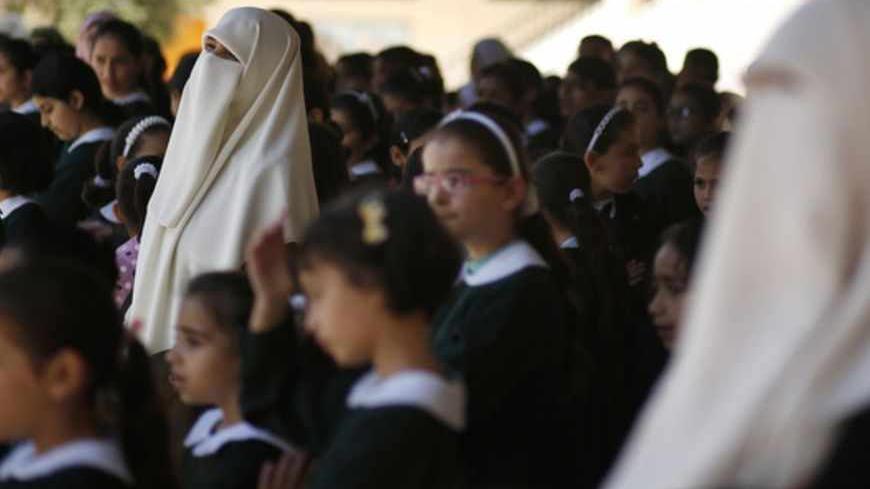 Teachers stand among school girls during a queue exercise at al-Qahera school in Gaza City April 2, 2013. New rules from the Education Ministry of the Islamist Hamas movement ruling the Gaza Strip will bar men from teaching at girls' schools and mandate separate classes for boys and girls from the age of nine. REUTERS/Mohammed Salem (GAZA - Tags: POLITICS EDUCATION) - RTXY5MN