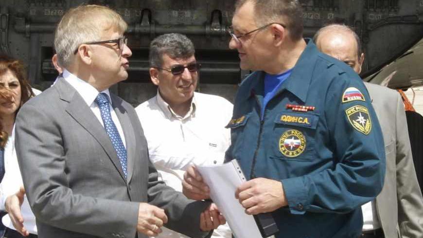 Russian ambassador to Lebanon Alexander Zasypkin (front L) talks with the pilot of a Russian aeroplane that arrived with humanitarian aid for Syrian refugees in Lebanon, at Beirut international airport April 3, 2013. REUTERS/Sharif Karim (LEBANON - Tags: POLITICS SOCIETY CONFLICT) - RTXY6RO