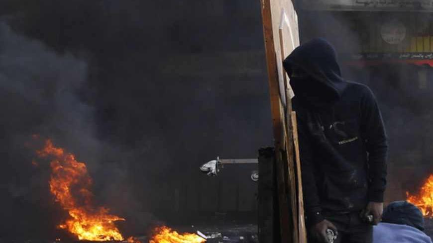A stone-throwing Palestinian protester looks from behind a make-shift barricade during clashes with Israeli soldiers following the funeral of Maysara Abu Hamdeya in the West Bank city of Hebron April 4, 2013. Thousands of mourners turned out on Thursday for the funerals of three Palestinians, including two teenagers killed by Israeli army gunfire in some of the worst violence in the occupied West Bank in years. The upsurge in unrest was triggered on Tuesday by the death of Hamdeya, a 64-year-old prisoner se