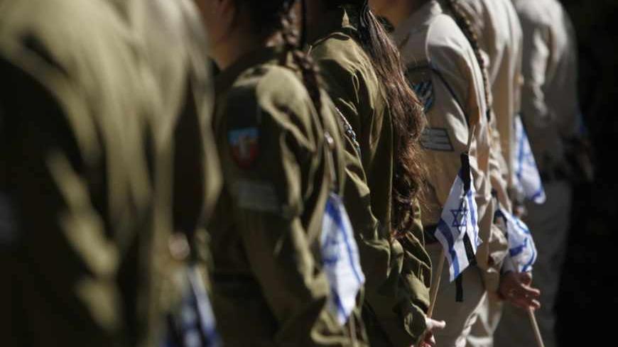 Israeli soldiers hold flags before placing them on the graves of fallen soldiers during a ceremony at the Mount Herzl military cemetery in Jerusalem, ahead of Memorial Day, April 10, 2013. Israel commemorates its fallen soldiers on Memorial Day, which begins Sunday night. REUTERS/Ronen Zvulun (JERUSALEM - Tags: POLITICS ANNIVERSARY CONFLICT) - RTXYGCO