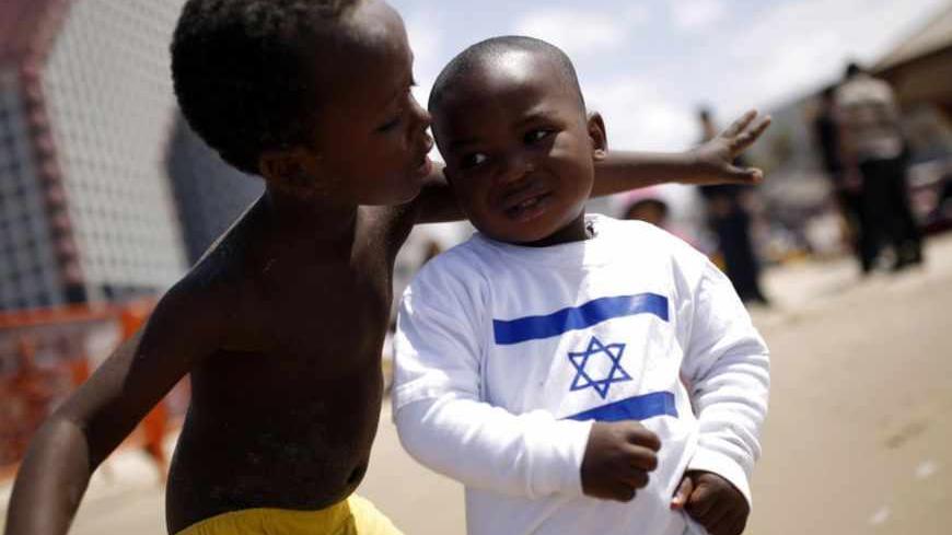 Children of migrant workers play on a beach in Tel Aviv, on Israel's Independence Day, marking the 65th anniversary of the creation of the state, April 16, 2013. REUTERS/Amir Cohen (ISRAEL - Tags: SOCIETY IMMIGRATION ANNIVERSARY) - RTXYNUK