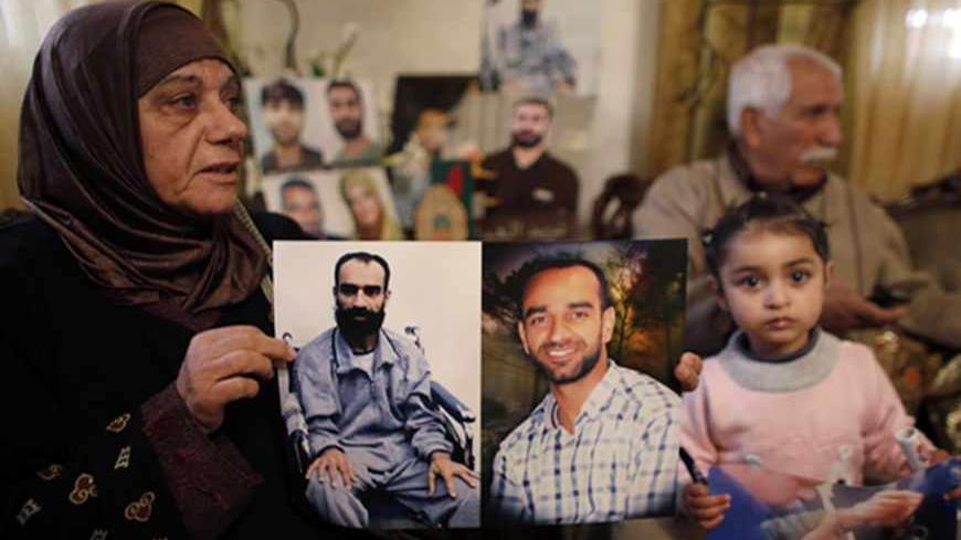 Layla al-Issawi holds a picture of her son Samer, who has been on hunger strike for 209 days while being held in an Israeli prison, at her home in the East Jerusalem neighbourhood of Issawiya February 17, 2013. The European Union on Saturday called on Israel to improve conditions for Palestinians in its jails, and a Palestinian minister said there would be rallies next week to support hunger-striking prisoners. Nearly 5,000 Palestinians are held in Israeli jails, many charged with involvement in attacks on
