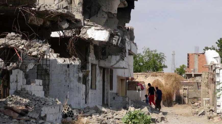 Yemenis walk past destroyed buildings in Zinjibar,  capital of Abyan province in southern Yemen on December 5, 2012, six months after the Yemeni army ousted al-Qaeda loyalists from the region. Before a counter-offensive by the army earlier this year, Al-Qaeda held large swathes of southern Yemen. But since its loss of a string of towns near the port city of Aden in June, most have fled into desert regions farther east. Although weakened, they continue to launch hit-and-run attacks on government and civilian