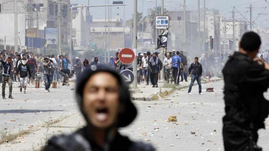 Supporters of Islamist group Ansar al-Sharia clash with riot police at Hai al Tadamon in Tunis May 19, 2013. Supporters of the hardline Islamist group clashed with Tunisian police in two cities on Sunday after the government banned its annual rally and the regional arm of al Qaeda urged it to stand firm against the authorities. REUTERS/Anis Mili (TUNISIA - Tags: CIVIL UNREST POLITICS RELIGION) - RTXZSQP