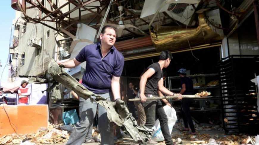 Iraqis clean up outside a bakery after a bomb exploded on a bus nearby in Baghdad?s Shiite Sadr City district on May 28, 2013. Bombings and shootings in Iraq killed 16 people, many of them security forces members, officials said, the latest in a wave of violence that authorities are struggling to contain. AFP PHOTO/ALI AL-SAADI        (Photo credit should read ALI AL-SAADI/AFP/Getty Images)