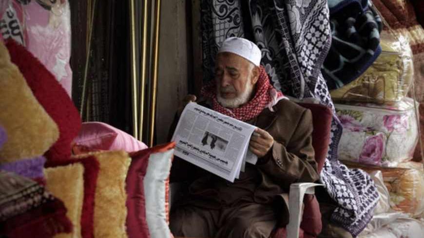 JABALIYA, GAZA - MARCH 29: A Palestinian shop-owner reads a newspaper outside his store on March 29, 2010, Jabaliya, Gaza Strip. Gaza's economy and employment levels have plummeted since the Israelis imposed a blockade after Hamas seized control in 2007. (Photo by Warrick Page/Getty Images)