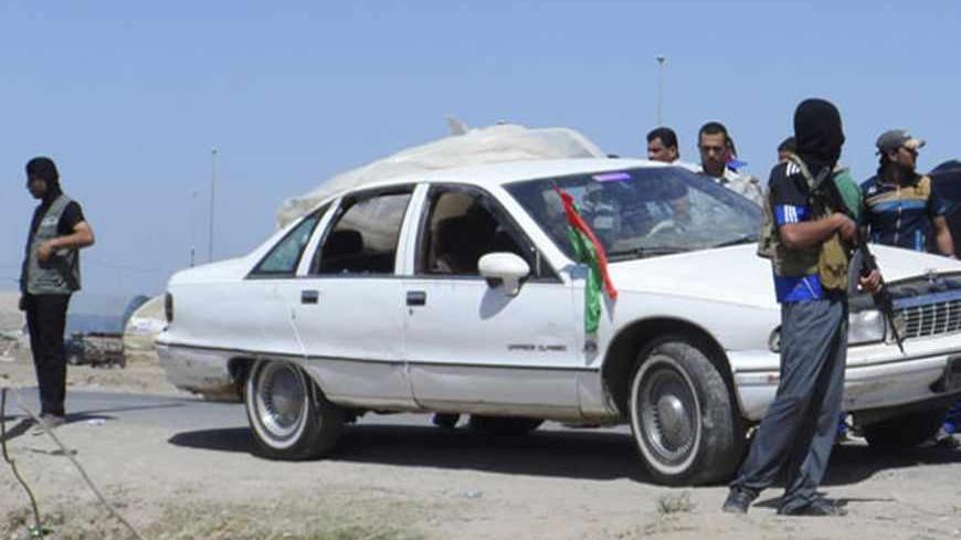 A masked Iraqi gunman stands guard near a civilian vehicle after attacking it in Ramadi, 100 km (62 miles) west of Baghdad April 27, 2013. At least five Iraqi soldiers in civilian clothes were killed and one wounded when gunmen attacked their vehicle Ramadi, Anbar Governorate, early Saturday, police sources said.
 REUTERS/Stringer (IRAQ - Tags: CIVIL UNREST) - RTXZ1LB