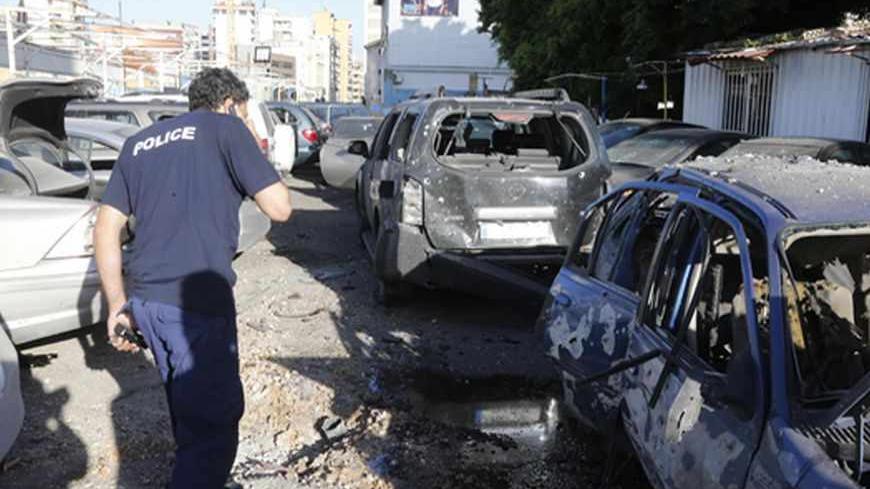 A policeman inspects damaged cars after two rockets hit houses and a car sales yard in Beirut suburbs May 26, 2013.  Two rockets hit a Shi'ite Muslim district of southern Beirut on Sunday, residents said, wounding several people, a day after the leader of Lebanese Shi'ite militant movement Hezbollah said his group would continue fighting in Syria until victory.  REUTERS/Mohammed Azakir       (LEBANON - Tags: CIVIL UNREST) - RTX1015N