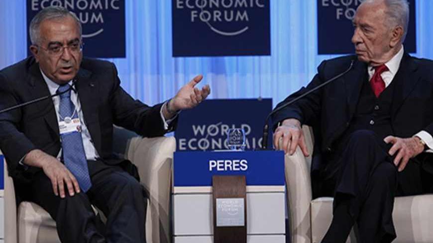 Palestinian Prime Minister Salam Fayyad (L) speaks next to Israel's President Shimon Peres during a session at the World Economic Forum (WEF) in Davos, January 26, 2012. REUTERS/Arnd Wiegmann (SWITZERLAND - Tags: POLITICS BUSINESS) - RTR2WWBB