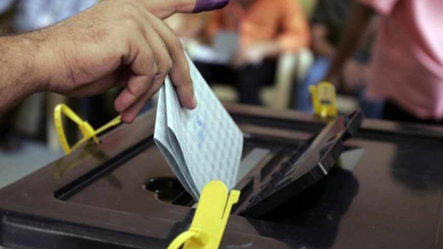An Iraqi Kurdish resident casts his ballot at a box during the regional parliament elections of the Kurdistan region in Baghdad July 25, 2009. Iraqi Kurds voted on Saturday in elections expected to keep Kurdistan President Masoud Barzani in power but unlikely to erase voter concerns about corruption or end a bitter feud with Baghdad over land and oil.  REUTERS/Saad Shalash (IRAQ ELECTIONS POLITICS) - RTR260ZV