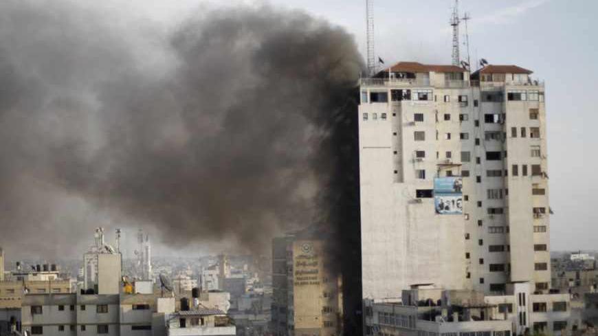 Smoke is seen after an after an Israeli air strike, witnessed by a Reuters journalist, out of a floor in a building that also houses media offices in Gaza City November 19, 2012. An Islamic Jihad local commander was killed on Monday in an Israeli air strike on a tower block that houses many international media, a source in the militant group said. REUTERS/Ahmed Jadallah (GAZA - Tags: MILITARY CONFLICT MEDIA) - RTR3AM74