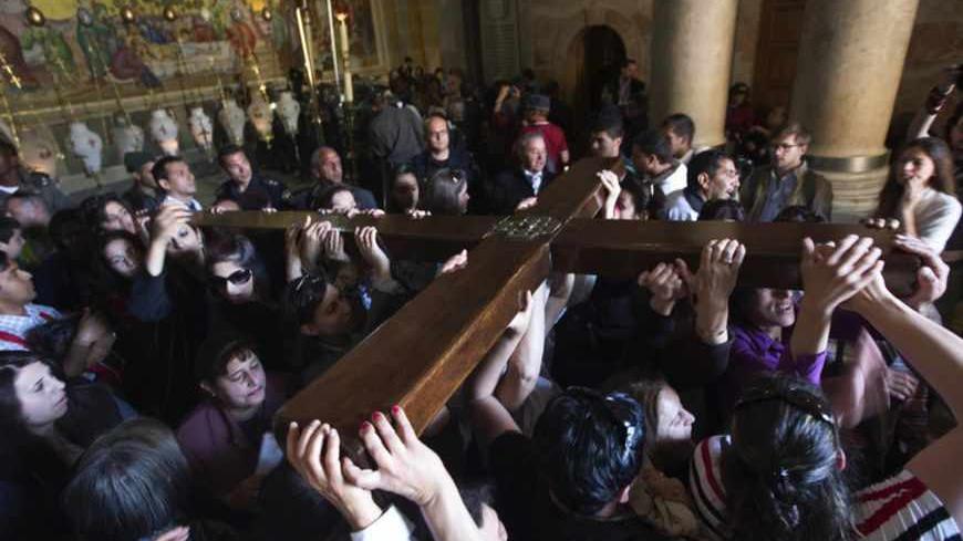 Worshippers carry a cross in the Church of the Holy Sepulchre on Good Friday during Holy Week, in Jerusalem's Old City March 29, 2013. Christian worshippers retraced the route Jesus took along Via Dolorosa to his crucifixion in the Church of the Holy Sepulchre. Holy Week is celebrated in many Christian traditions during the week before Easter. REUTERS/Nir Elias (JERUSALEM - Tags: RELIGION) - RTXY1SJ