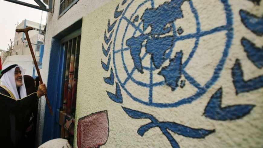 A Palestinian refugee knocks on the closed gate of the United Nations Relief and Works Agency (UNRWA) headquarters with his walking stick, during a protest demanding UNRWA to resume aid for refugees in Gaza City April 8, 2013. The main U.N. humanitarian agency for Palestinians closed all of its relief and distribution centres in Gaza after protesters stormed its headquarters on Thursday demanding it to reverse a decision to cut annual cash handouts of $40 for the poorest beneficiaries. REUTERS/Suhaib Salem 