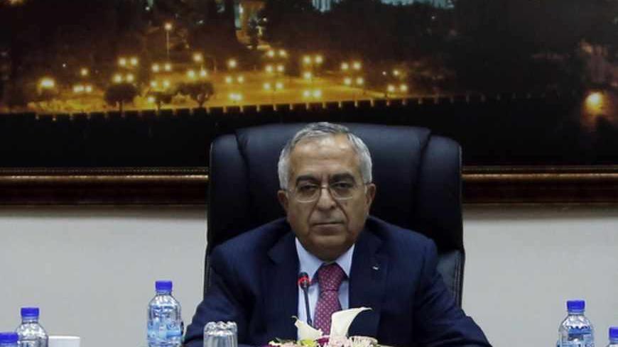 Palestinian Prime Minister Salam Fayyad sits at the head of a Palestinian cabinet meeting in the West Bank city of Ramallah April 16, 2013. Abbas accepted Fayyad's resignation on Saturday, but is likely to keep him in office for the next few weeks while the U.S. tries to revive Middle East peace talks, officials said on Monday. REUTERS/ Mohamed Torokman (WEST BANK - Tags: POLITICS) - RTXYNV1