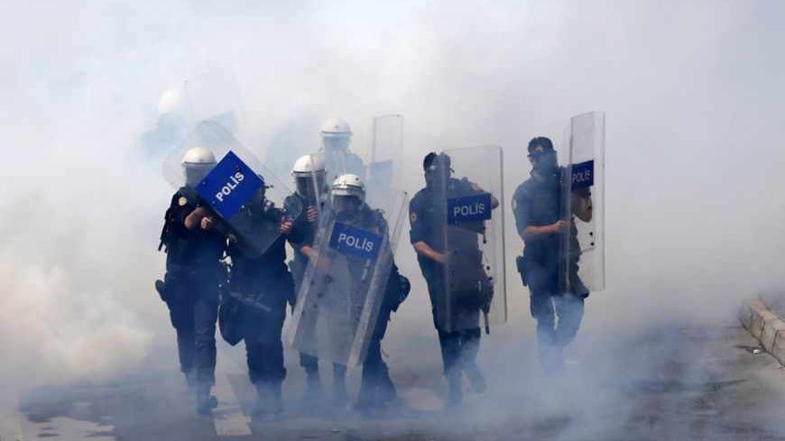 Riot police walk through a cloud of tear gas as they clash with May Day protesters trying to break through barricades to reach the city's main square in central Istanbul May 1, 2013. Turkish riot police clashed with thousands of May Day protesters in Istanbul on Wednesday, firing water cannon and tear gas at crowds that tried to break through barricades to reach the city's main square, witnesses said. The incidents followed the pattern of recent years, when May Day demonstrations in Turkey's largest city ha