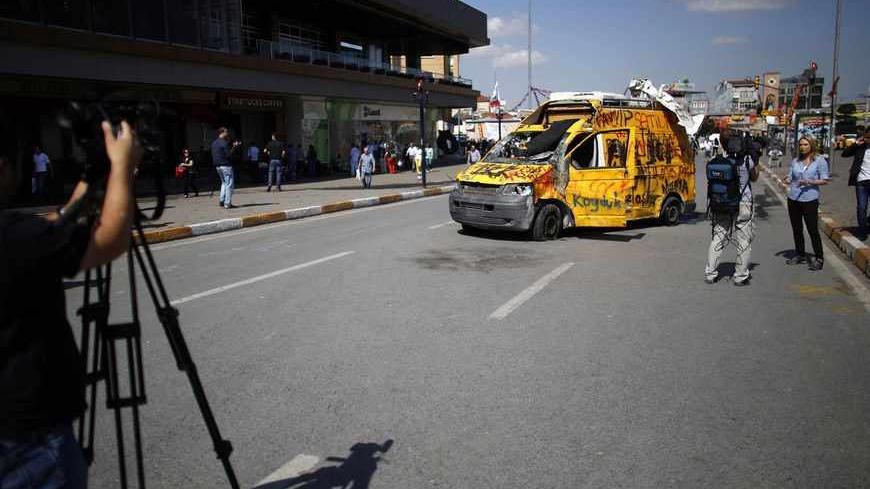 TV crews film near a damaged broadcaster's satellite news network truck at Taksim Square in central Istanbul June 3, 2013. Turkish protesters clashed with riot police into the early hours of Monday with some setting fire to offices of the ruling AK Party as the fiercest anti-government demonstrations in years entered their fourth day. Turkey's streets were calm in the morning after a night of noisy protests and violence in major cities. REUTERS/Stoyan Nenov (TURKEY  - Tags: POLITICS MEDIA CIVIL UNREST) - RT