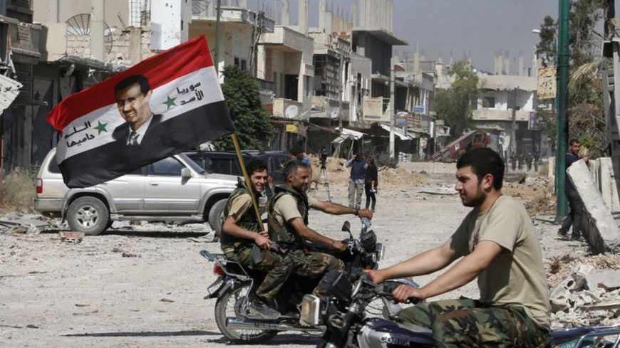 Forces loyal to Syria's President Bashar al-Assad carry the national flag as they ride on motorcycles in Qusair, after the Syrian army took control from rebel fighters, June 5, 2013. Syrian government forces and their Lebanese Hezbollah allies seized control of the border town of Qusair on Wednesday, dealing a major defeat to rebel fighters battling to overthrow Assad. REUTERS/Mohammed Azakir (SYRIA - Tags: CONFLICT MILITARY POLITICS CIVIL UNREST) - RTX10CO4