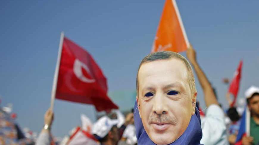 A supporter wears a mask showing Turkish Prime Minister Tayyip Erdogan during a rally of ruling AK party in Istanbul June 16, 2013. Tens of thousands of Erdogan's supporters massed at a rally in Istanbul on Sunday, as riot police fired tear gas to break up pockets of anti-government protesters in the city center several kilometers away. REUTERS/Murad Sezer (TURKEY  - Tags: POLITICS CIVIL UNREST)   - RTX10PV2