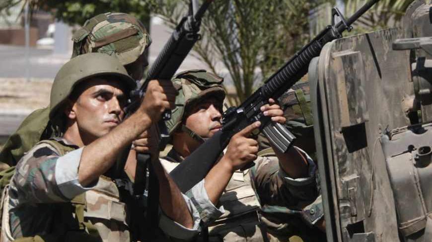 Lebanese army soldiers point their weapons during clashes with gunmen of hardline Sunni Muslim cleric Sheikh Ahmed al-Assir, in Abra near Sidon, southern Lebanon, June 24, 2013. Lebanese soldiers fought Sunni Muslim gunmen in the southern city of Sidon on Monday in one of the deadliest outbreaks of violence fuelled by sectarian divisions over the civil war in neighbouring Syria. REUTERS/Sharif Karim  (LEBANON - Tags: POLITICS CIVIL UNREST MILITARY) - RTX10YUO