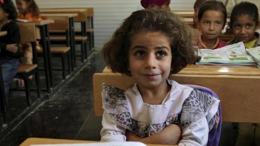 Syrian students sits in a UNICEF school during a visit by European Union Commissioner for International Cooperation, Humanitarian Aid and Crisis Response Kristalina Georgieva and Italy's Foreign Minister Emma Bonino at the Al Zaatri refugee camp in the Jordanian city of Mafraq, near the border with Syria June 25, 2013. REUTERS/Muhammad Hamed (JORDAN - Tags: EDUCATION CONFLICT SOCIETY) - RTX1106A