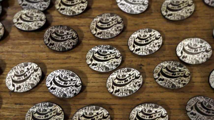 Campaign pins of Iranian presidential candidate and lead nuclear negotiator Saeed Jalili are displayed for sale at Tehran University in the Iranian capital on June 3, 2013. The eight candidates standing for president this month may differ on several issues, but when it comes to Iran's nuclear drive they are united in pursuing what they see as its peaceful atomic ambitions. AFP PHOTO/ATTA KENARE        (Photo credit should read ATTA KENARE/AFP/Getty Images)
