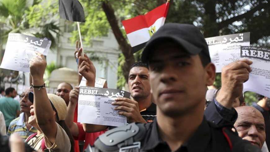 Anti-Mursi protesters, made up of intellectuals and artists, hold up signs reading: "rebel", in front of the Ministry of Culture during a demonstration against what they claimed are increasing influence of the Muslim Brotherhood over the Ministry of Culture and Minister of Culture Alaa Abdel Aziz, in Cairo June 11, 2013. Egyptian President Mohamed Mursi increased the influence of his Muslim Brotherhood over government in a cabinet reshuffle in May that replaced two ministers involved in crucial talks with t