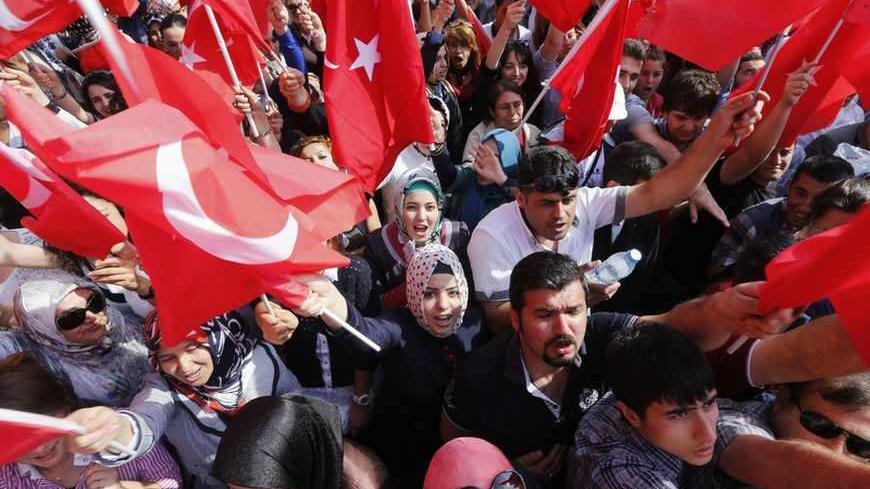 Supporters of Turkey's Prime Minister Tayyip Erdogan wave flags, hold banners and shout slogans as they wait for his arrival at Esenboga Airport in Ankara June 9, 2013. Still by far the country's most popular politician, Erdogan has pressed ahead with government business as usual.    REUTERS/Umit Bektas (TURKEY - Tags: POLITICS CIVIL UNREST TPX IMAGES OF THE DAY) - RTX10HBN