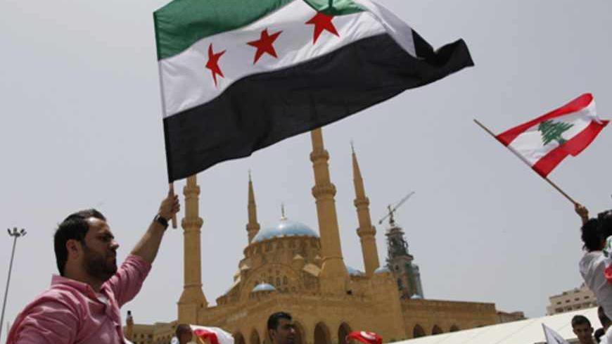 Anti-Hezbollah activists wave Syrian opposition (L) and Lebanese national flags during a protest in Beirut June 9, 2013. A Lebanese protester was killed outside the Iranian embassy in Beirut on Sunday after gunmen from the Iranian-backed Shi'ite militia Hezbollah opened fire when anti-Hezbollah Shi'ite demonstrators approached, witnesses and officials said.               REUTERS/Jamal Saidi                   (LEBANON - Tags: CIVIL UNREST POLITICS) - RTX10H9O