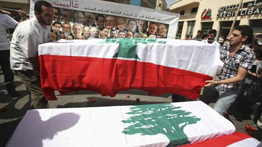 Protesters carry mock coffins draped with Lebanon's national flags, representing the parliament, as they express their refusal of the extension of parliamentary terms near the parliament in Beirut May 31, 2013. Lebanese lawmakers agreed on Friday to postpone a June parliamentary election until late next year due to instability in neighbouring Syria and political deadlock at home. Words on the banner read, "You failed in everything. You failed, you failed, you failed... Go home!" REUTERS/Sharif Karim (LEB