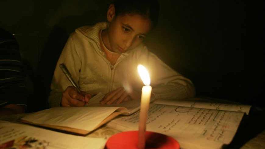 A Palestinian girl studies by candle light during a power cut in Gaza November 13, 2008 November 13, 2008. A United Nations aid agency said on Thursday it had run out of food supplies for 750,000 Palestinians in the Hamas-run Gaza Strip after Israel blocked deliveries by the world body.Short of fuel, Palestinian officials shut down Gaza's sole power plant as Israel kept commercial crossings with the coastal territory closed for a 10th day. REUTERS/Ismail Zaydah (GAZA) - RTXAK2X
