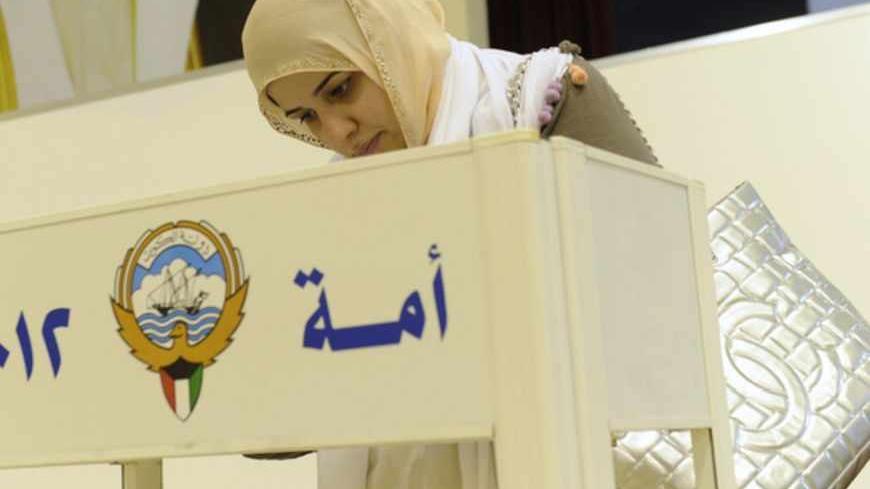 A woman votes at a polling station in Kuwait city February 2, 2012. Kuwaitis headed to the polls on Thursday for the fourth time in six years in a snap parliamentary election in which opposition candidates expect to expand their influence and push for change in the oil-exporting Gulf Arab state. REUTERS/Stringer (KUWAIT - Tags: POLITICS ELECTIONS) - RTR2X7TI
