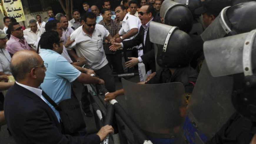 Egypt's opposition members shouts slogans against against Egyptian President Mohamed Mursi and members of the Muslim Brotherhood as they clash with riot police during a protest against the new judicial law in front of Egypt's Shura Council in Cairo May 25, 2013. Egypt's highest court ruled on Saturday that parts of a revised election law setting out terms for a parliamentary election were unconstitutional, casting fresh doubt over a poll that has already been delayed. The Shura Council has approved, Saturda