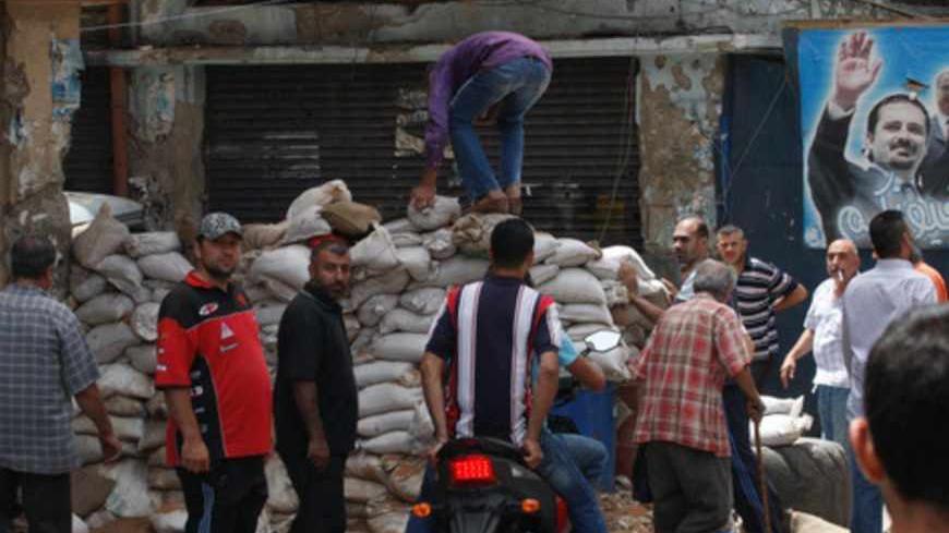 Lebanese residents remove barricades after months of clashes between Sunni Muslims and the small Alawite community, in Tripoli June 9, 2013.    REUTERS/Stringer (LEBANON - Tags: POLITICS CIVIL UNREST) - RTX10HDG