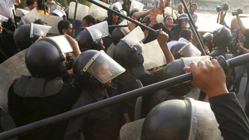 Riot police attempt to separate anti-Mursi protesters made up of intellectuals and artists and supporters of Egyptian President Mohamed Mursi in front of the Ministry of Culture during a demonstration against what they claimed are increasing influence of the Muslim Brotherhood over the Ministry of Culture and Minister of Culture Alaa Abdel Aziz, in Cairo June 11, 2013. Mursi increased the influence of his Muslim Brotherhood over government in a cabinet reshuffle in May that replaced two ministers involved i
