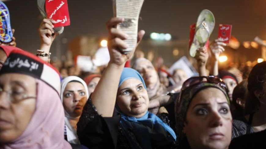 Protesters raise their shoes while chanting anti-Mursi and anti-Muslim Brotherhood slogans in Tahrir square as they listen to President Mohamed Mursi's public address, in Cairo June 26, 2013. Mursi offered opponents a say on Wednesday in amending a controversial new constitution and a forum to seek "national reconciliation", as he sought to avert a violent showdown in the streets. REUTERS/Asmaa Waguih (EGYPT - Tags: POLITICS CIVIL UNREST) - RTX112DX
