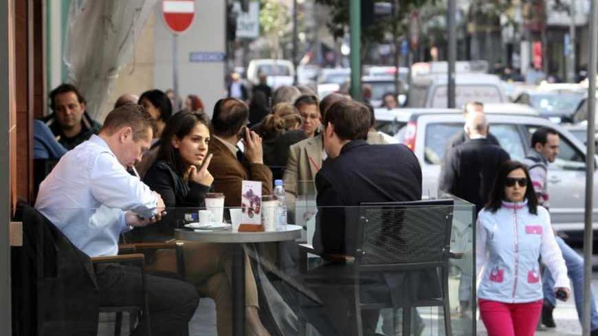 People sit in a coffee shop in Hamra street in Beirut January 24, 2011. Lebanon was plunged into political crisis after Hezbollah and its allies walked out of caretaker Prime Minister Saad al-Hariri's unity government on Jan. 12 in a dispute over still-confidential indictments by a U.N.-backed tribunal which is investigating the 2005 killing of statesman Rafik al-Hariri, the premier's father. Picture taken January 24, 2011. REUTERS/Sharif Karim (LEBANON - Tags: SOCIETY) - RTXX13K