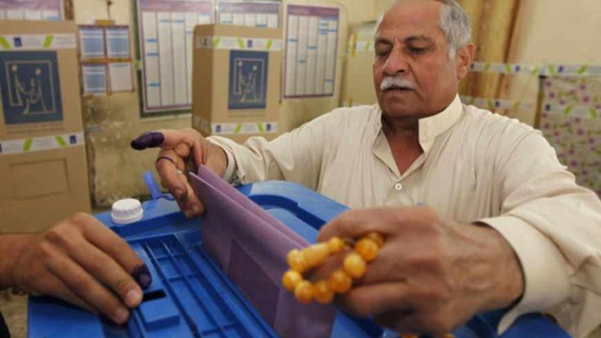 An Iraqi man casts his vote at a polling station in Baghdad April 20, 2013. Iraqis voted for provincial councils on Saturday in their first ballot since U.S. troops left the country, a key measure of political strength before parliamentary elections next year. REUTERS/Mohammed Ameen (IRAQ - Tags: POLITICS ELECTIONS) - RTXYT1T