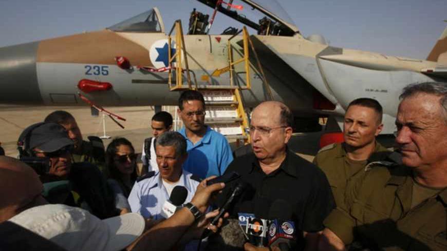 An Israeli Air Force F-15I jet is seen in the background as Israeli Defense Minister Moshe Yaalon (3rd R) speaks to reporters while standing next to Israel's armed forces chief Major-General Benny Gantz (R) and commander of Israel's Air Force Major-General Amir Eshel (4th R) during a presentation at Hatzerim air base in southern Israel April 30, 2013. Israel on Tuesday launched its first targeted attack on a militant in Gaza since a war in November, killing a Palestinian jihadist in an air strike that put f