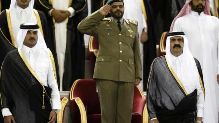 Qatar's Emir Sheikh Hamad bin Khalifa al-Thani (R) stands next to his son Crown Prince Sheikh Tamim bin Hamad al-Thani before the Emir Cup final match between Al-Sadd and Al-Rayyan at Khalifa stadium in Doha May 18, 2013. REUTERS/Fadi Al-Assaad (QATAR - Tags: SPORT SOCCER ROYALS POLITICS) - RTXZRXO