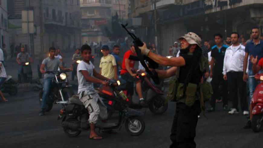 A Sunni Muslim gunman fires his weapon expressing his support with Salafist leader Ahmad al-Assir in Tripoli, northern Lebanon, June 23, 2013. At least three Lebanese soldiers were killed in the coastal city of Sidon on Sunday in clashes with followers of a Sunni Islamist cleric who is a fierce critic of Hezbollah's military intervention in neighbouring Syria, a security official said. Sources in the city said the fighting broke out when a follower of Sheikh Ahmed al-Assir was arrested at an army roadblock 