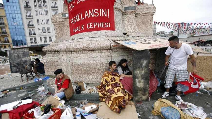 Demonstrators rest in Taksim Square where police and anti-government protesters clashed in central Istanbul June 2, 2013. Protesters lit fires and scuffled with police in parts of Istanbul and Ankara early on Sunday, but the streets were generally quieter after two days of Turkey's fiercest anti-government demonstrations for years. REUTERS/Murad Sezer (TURKEY - Tags: POLITICS CIVIL UNREST) - RTX108WO