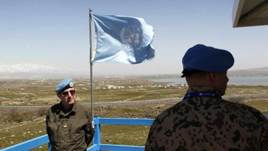 Peacekeeping troops from the unarmed United Nations Truce Supervision Organisation (R) (UNTSO) and the UN Disengagement Observer Force (L) (UNDOF) stand on an observation tower located on the Israeli side of the 1973 Golan Heights ceasefire line with Syria March 21, 2012. Blue-helmeted United Nations peacekeeping troops patrolling a slice of Syrian territory to maintain a ceasefire with Israel face new risks as violence between Syrian government loyalists and rebels gets closer. Picture taken March 21, 2012