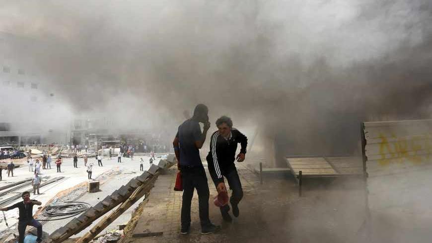 Anti-government protesters try to extinguish a burning container in Istanbul's Taksim square June 4, 2013. It was not clear why the container was on fire. Pockets of protesters clashed with Turkish riot police overnight and a union federation began a two-day strike on Tuesday as anti-government demonstrations in which two people have died stretched into a fifth day. REUTERS/Yannis Behrakis (TURKEY - Tags: CIVIL UNREST POLITICS) - RTX10B5F