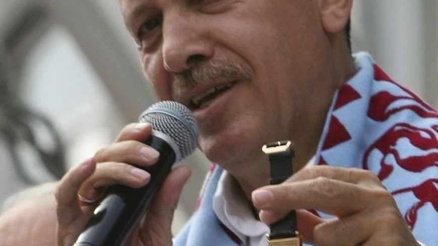 Turkish Prime Minister Tayyip Erdogan displays a watch with a signature of former Prime Minister Adnan Menderes engraved on it, during a rally of his ruling AK Party to campaign for Sunday's early parliamentary elections in Turkey's Black Sea city of Trabzon July 20, 2007. The watch was presented to him by a supporter. REUTERS/Fatih Saribas (TURKEY) - RTR1S2C8